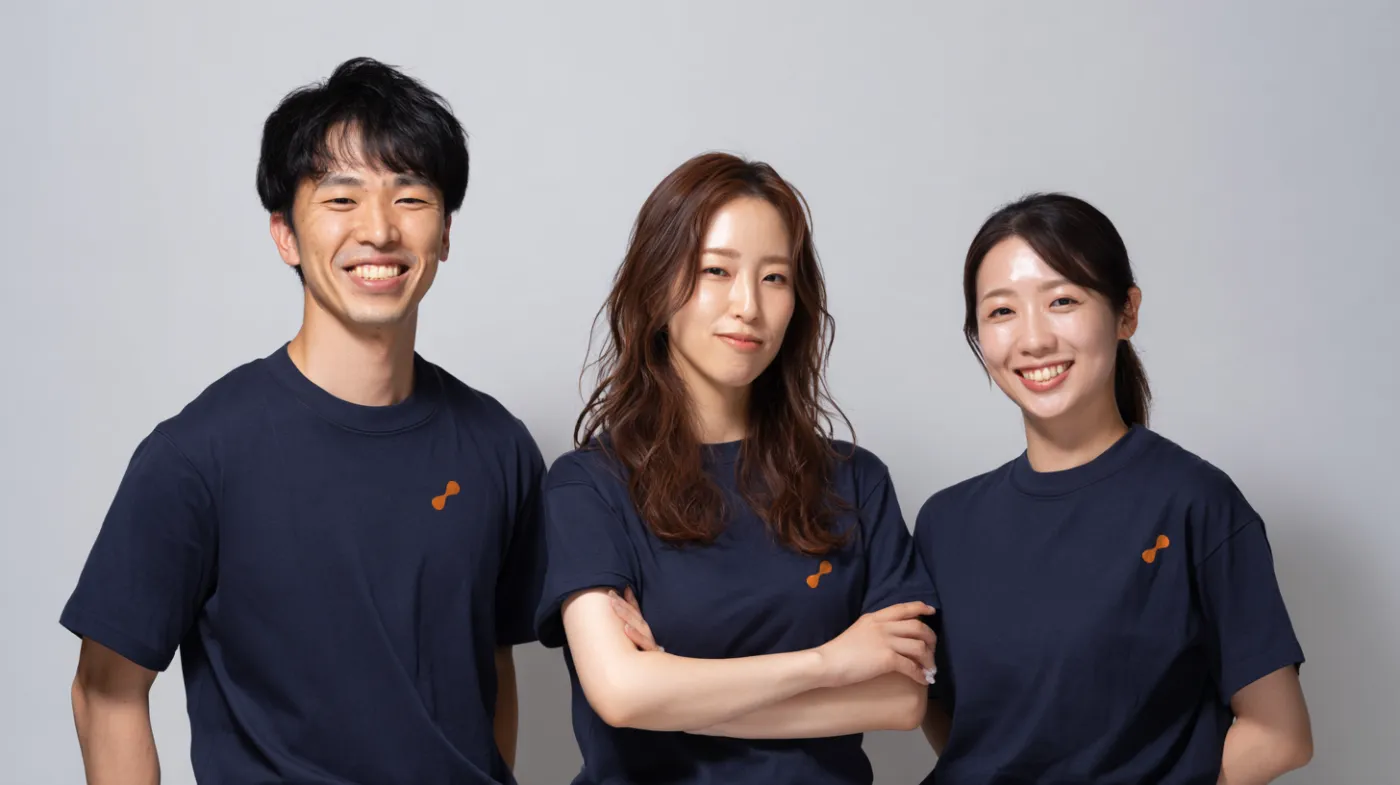 bookmi のロゴ入り T シャツを着たスタッフ 3 名